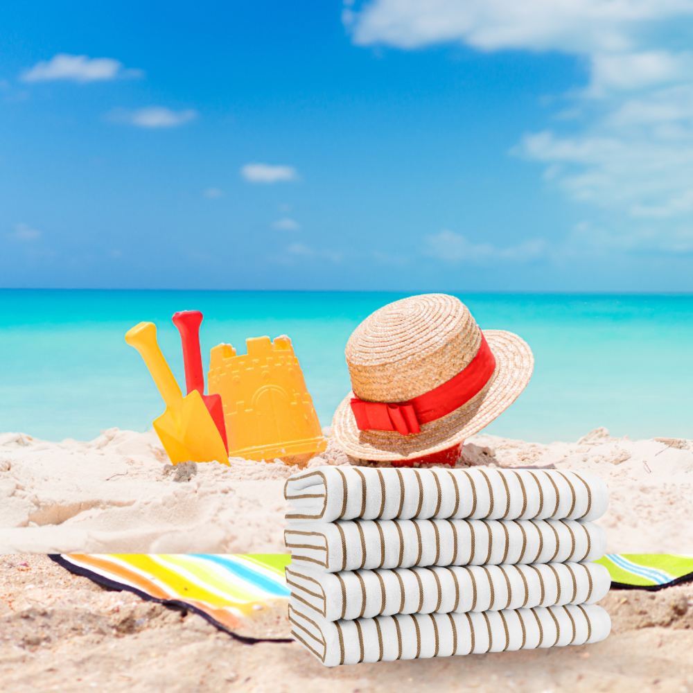 Four striped beach towels folded on the sand
