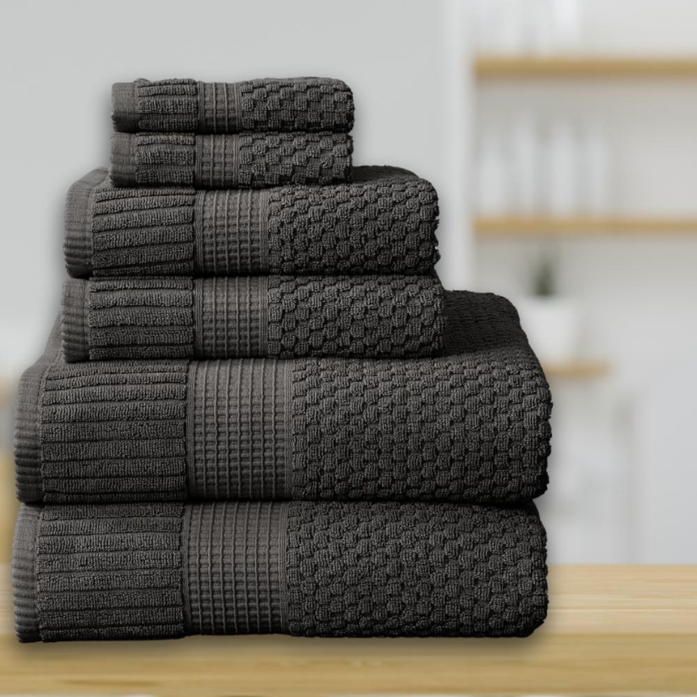 A six piece dark grey towel set stacked by size